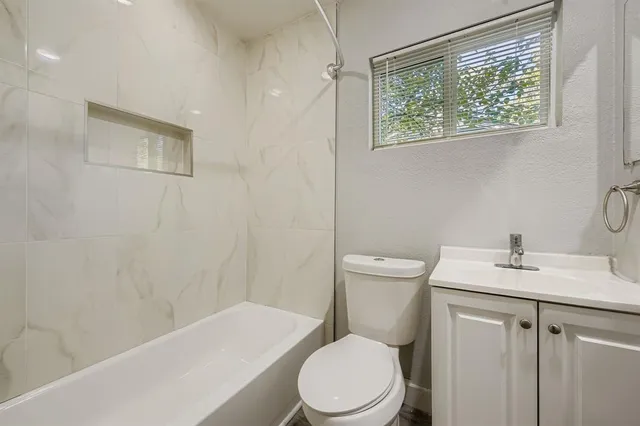 a white toilet sitting next to a bath tub