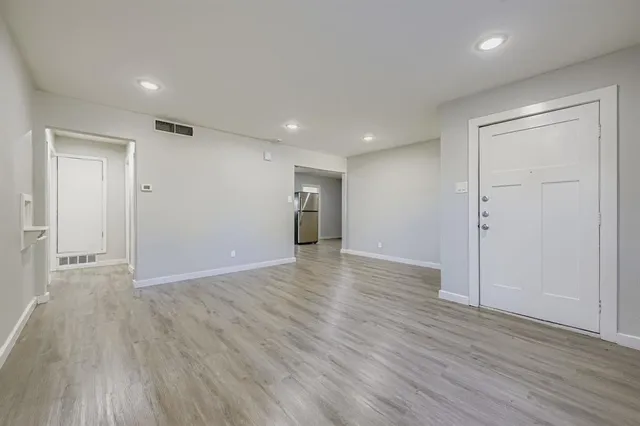 a view of an empty room with wooden floor