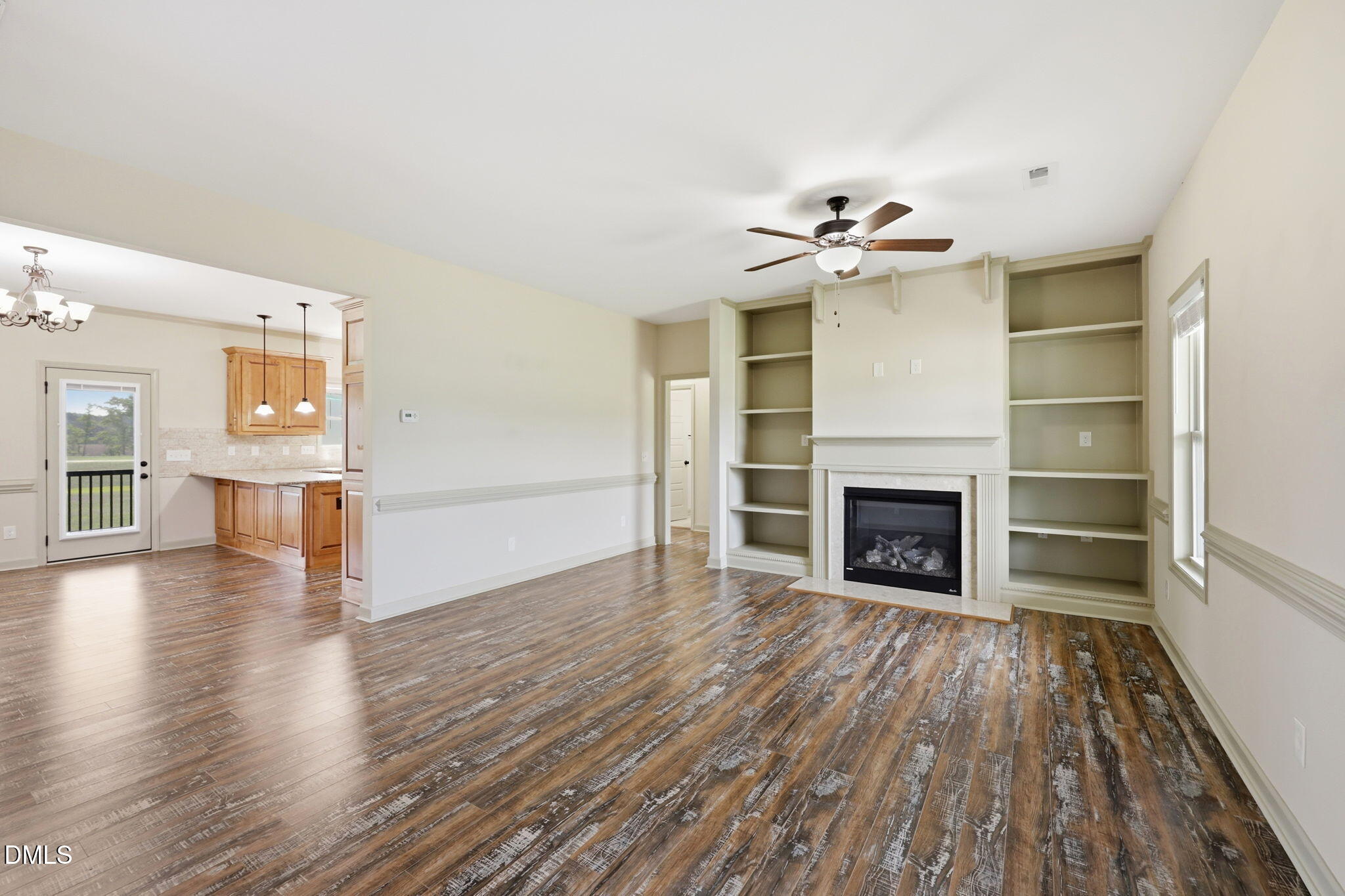 3587 Hannah Creek Road Benson, NC 27504 - Photo 6 of 43 wooden floor in an empty room with a fireplace and a window