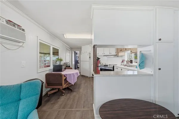 a living room with furniture a large window and kitchen view