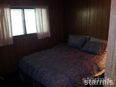a bed sitting in a bedroom next to a window