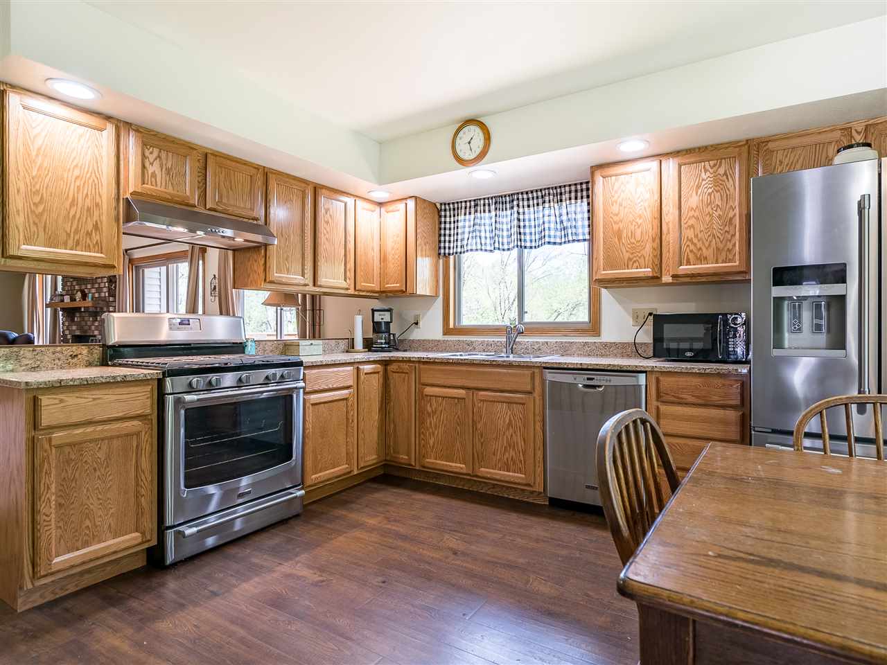 10201 North Campbell Road Durand, IL 61024 - Photo 15 of 20 a kitchen with stainless steel appliances granite countertop a stove a sink dishwasher a microwave oven and a dining table with wooden floor