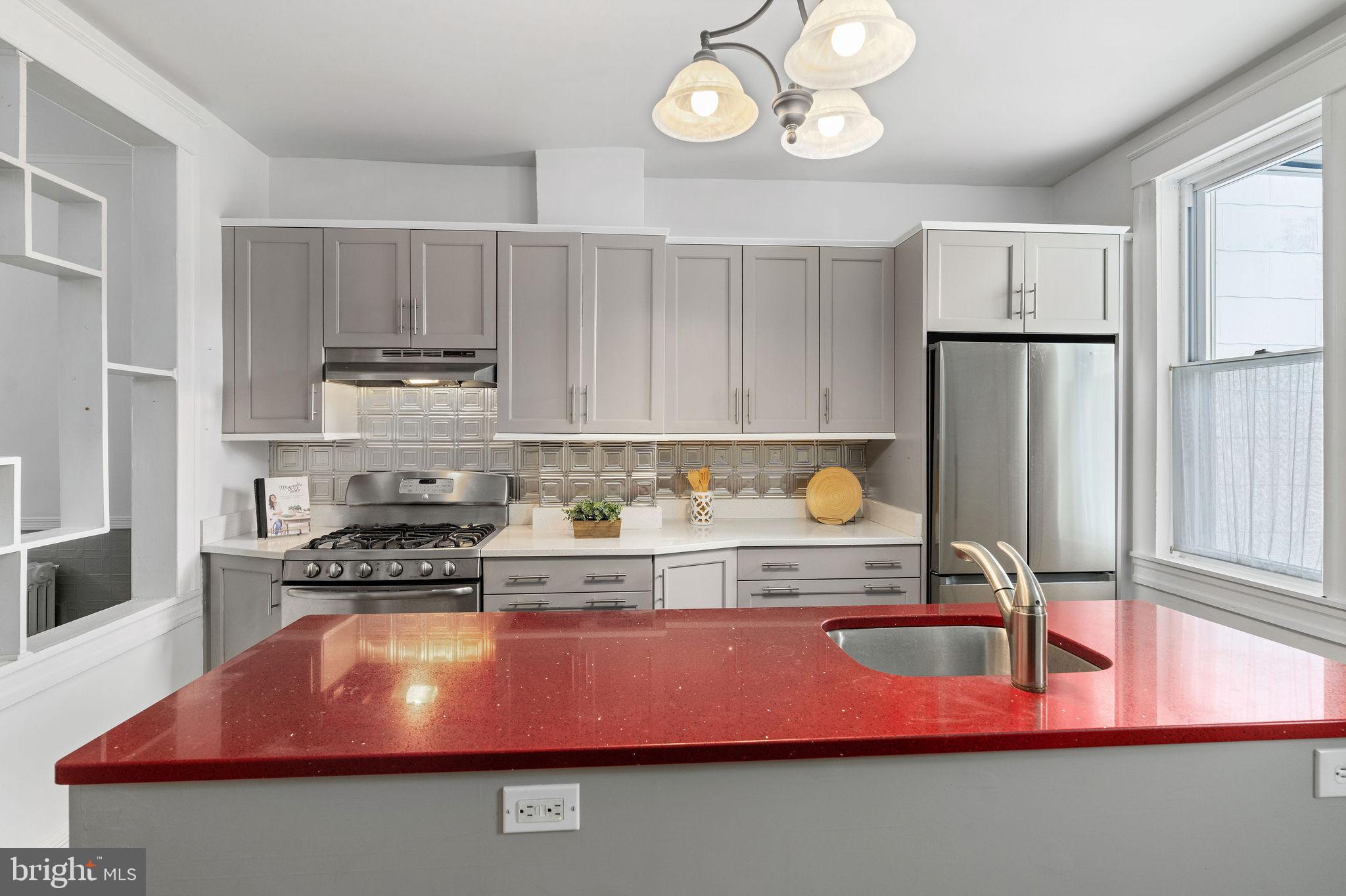 4148 Falls Road Baltimore, MD 21211 - Photo 15 of 37 a kitchen with stainless steel appliances granite countertop a sink dishwasher stove and refrigerator with wooden floor