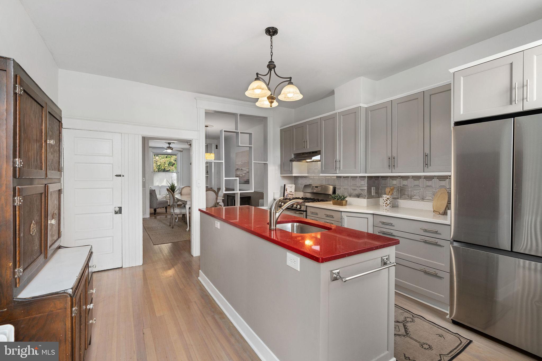 4148 Falls Road Baltimore, MD 21211 - Photo 17 of 37 a kitchen with stainless steel appliances granite countertop a refrigerator a sink dishwasher a stove and white countertops with wooden floor