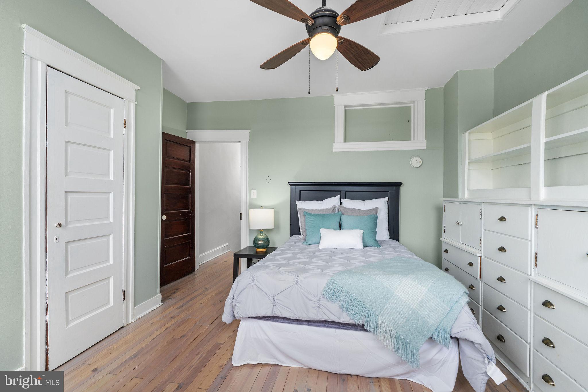 4148 Falls Road Baltimore, MD 21211 - Photo 25 of 37 a bedroom with a bed and wooden floor