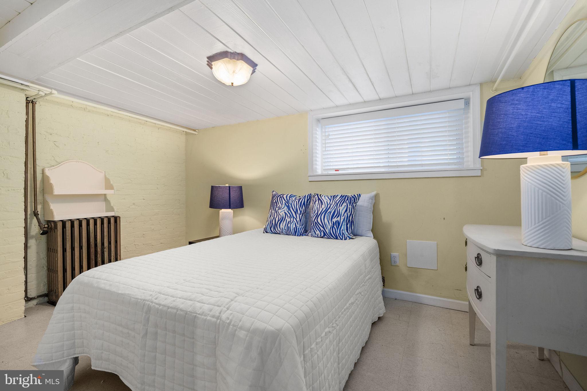 4148 Falls Road Baltimore, MD 21211 - Photo 28 of 37 a bedroom with a bed and a lamp