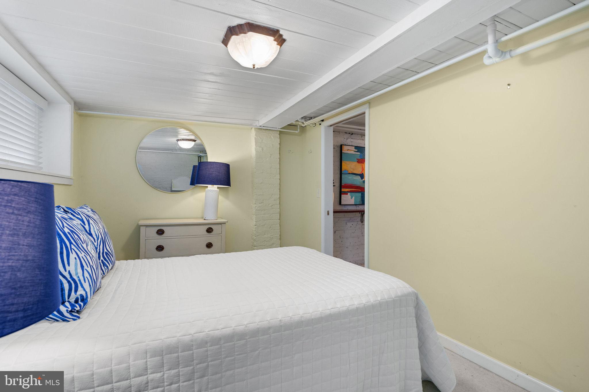 4148 Falls Road Baltimore, MD 21211 - Photo 29 of 37 a bedroom with a large bed and a chandelier