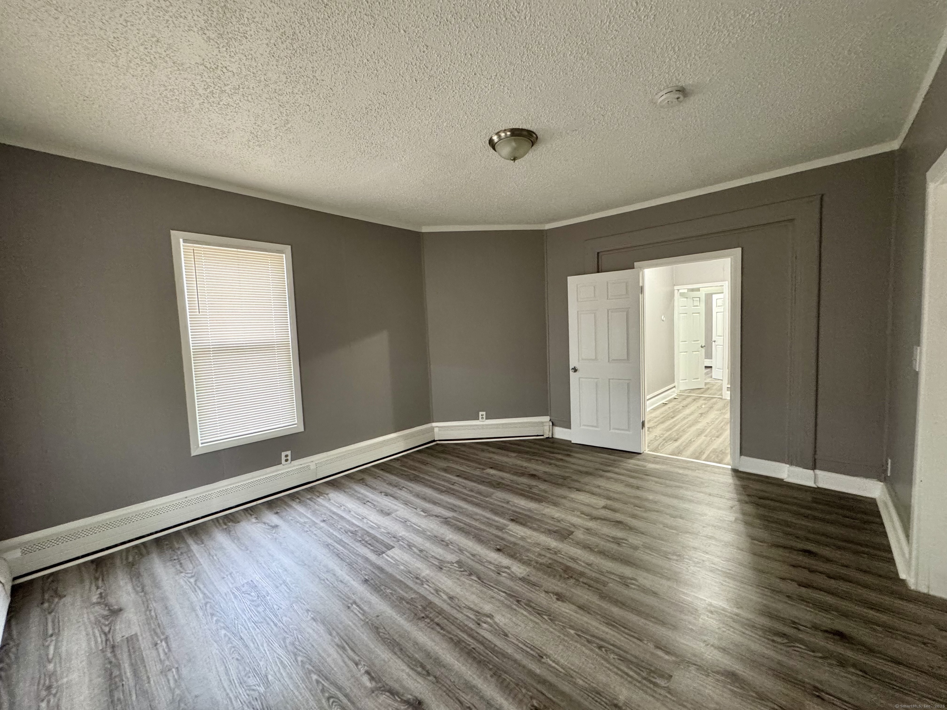 1102 East Main Street, Unit 1 Bridgeport, CT 06608 - Photo 13 of 14 a view of an empty room with wooden floor and a window