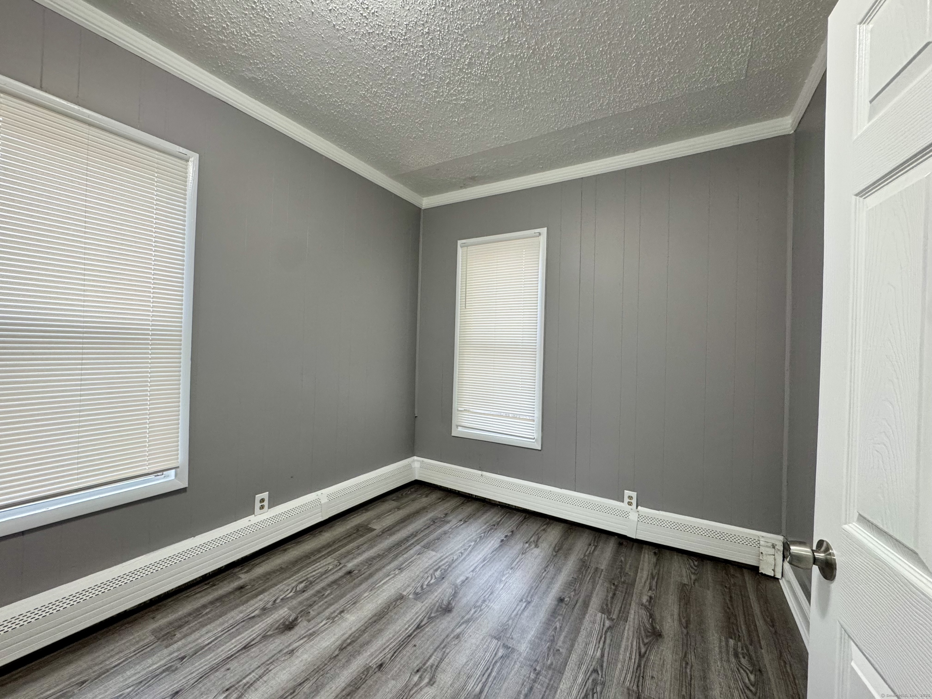 1102 East Main Street, Unit 1 Bridgeport, CT 06608 - Photo 14 of 14 an empty room with wooden floor and windows