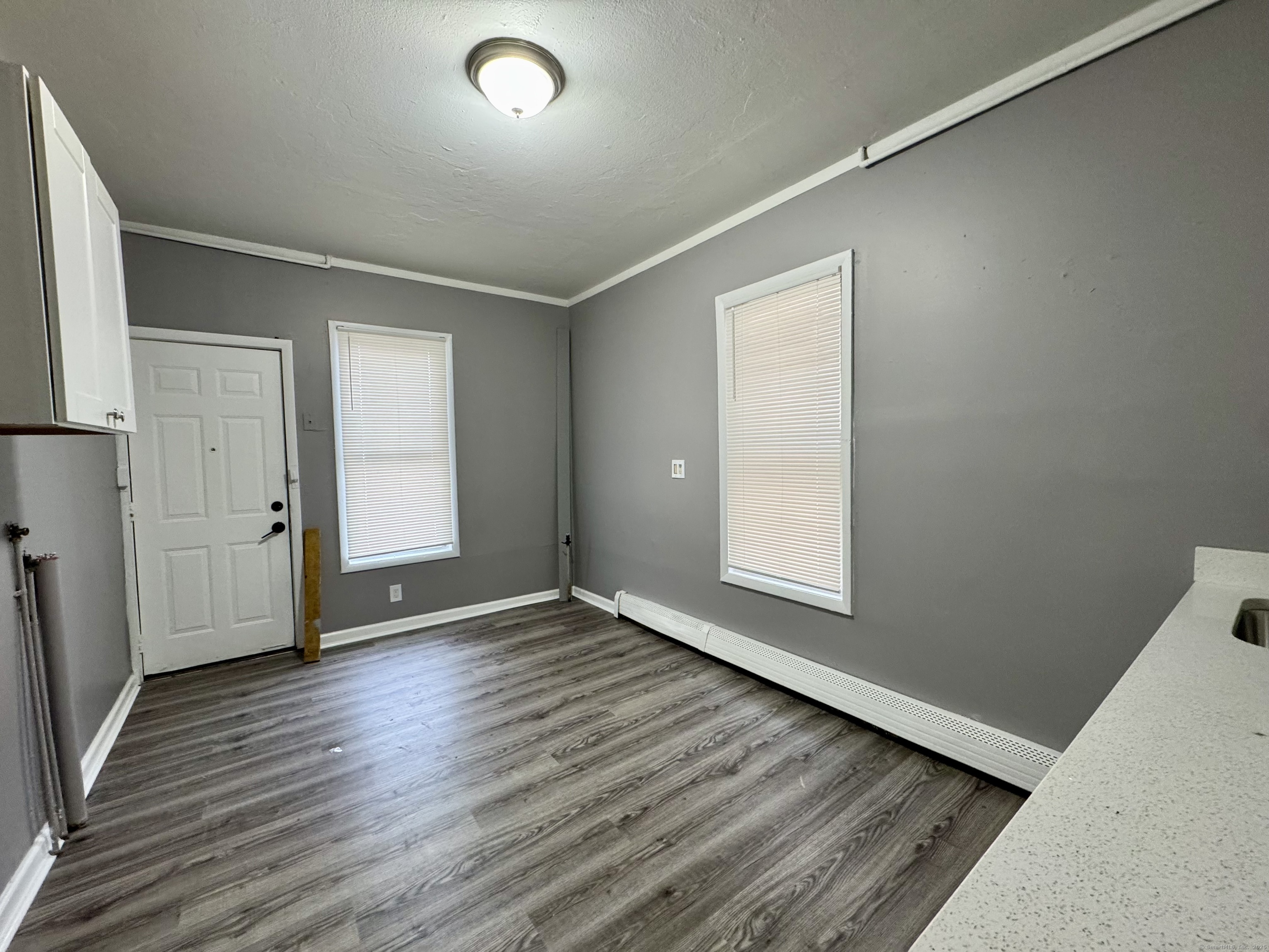 1102 East Main Street, Unit 1 Bridgeport, CT 06608 - Photo 5 of 14 an empty room with wooden floor and windows