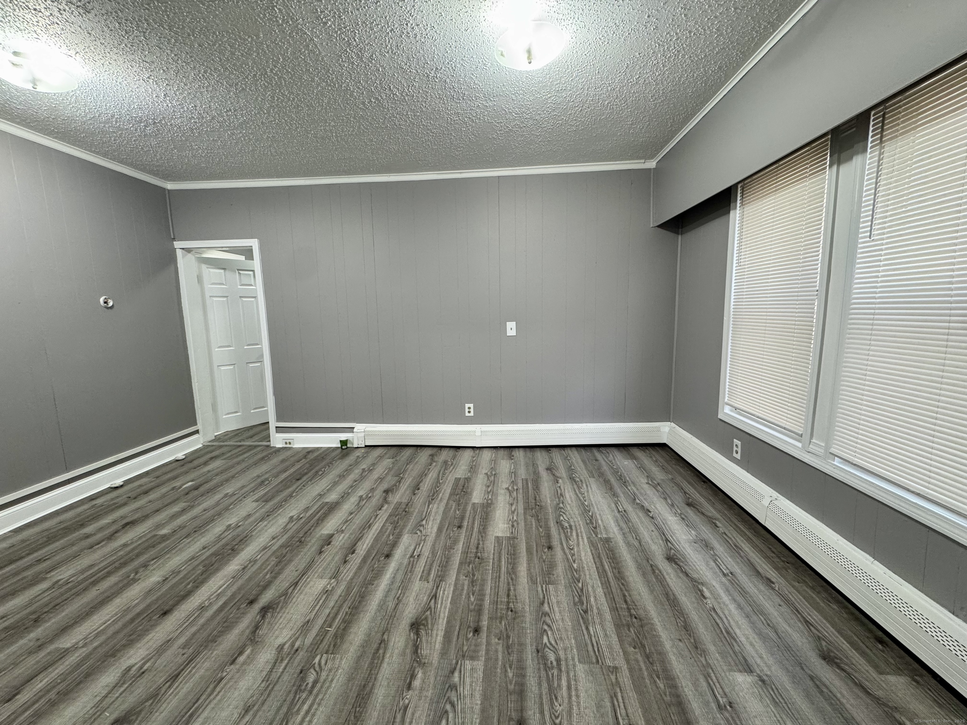 1102 East Main Street, Unit 1 Bridgeport, CT 06608 - Photo 6 of 14 a view of an empty room with wooden floor and a window