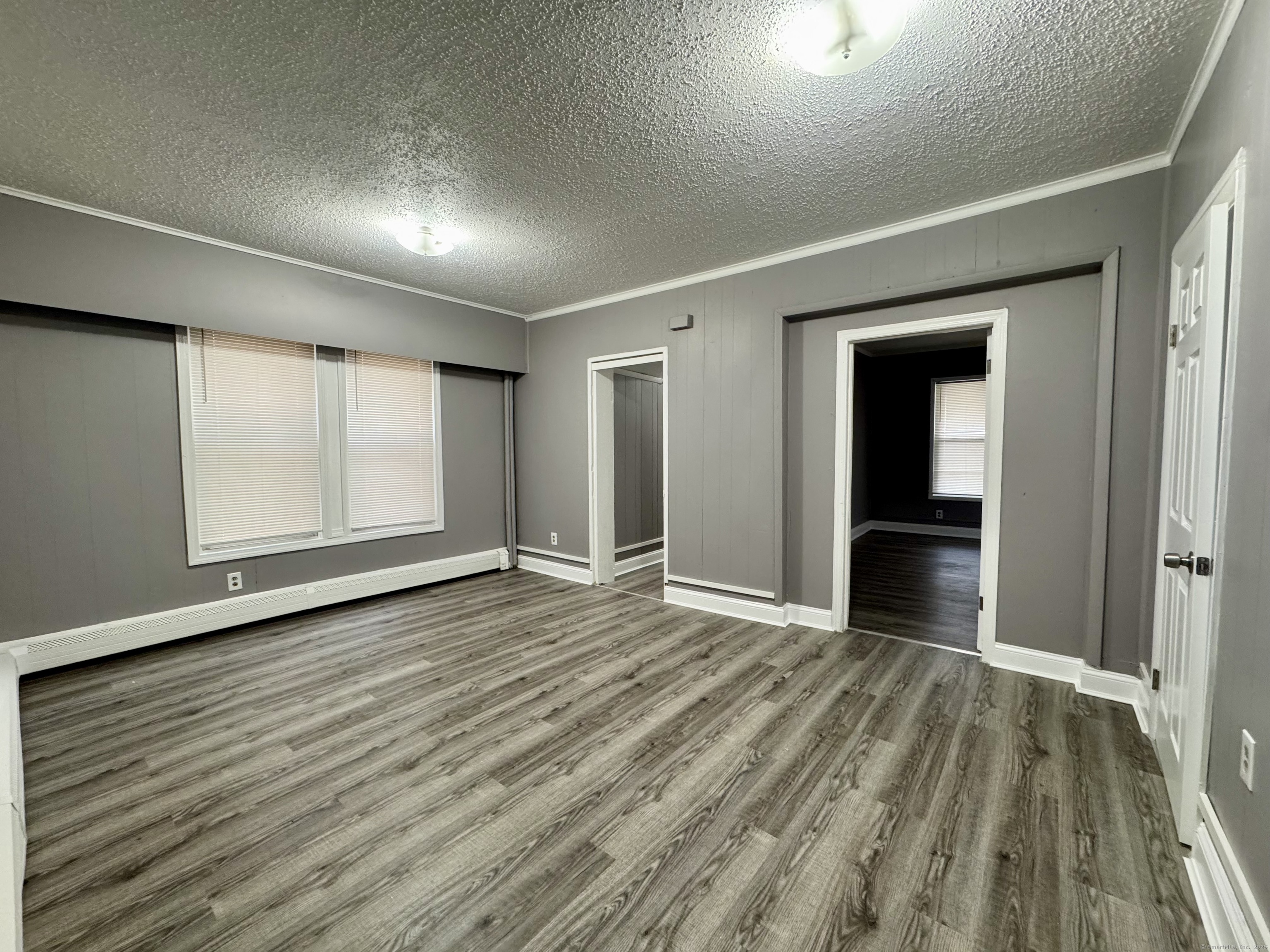 1102 East Main Street, Unit 1 Bridgeport, CT 06608 - Photo 7 of 14 a view of an empty room with wooden floor and a window