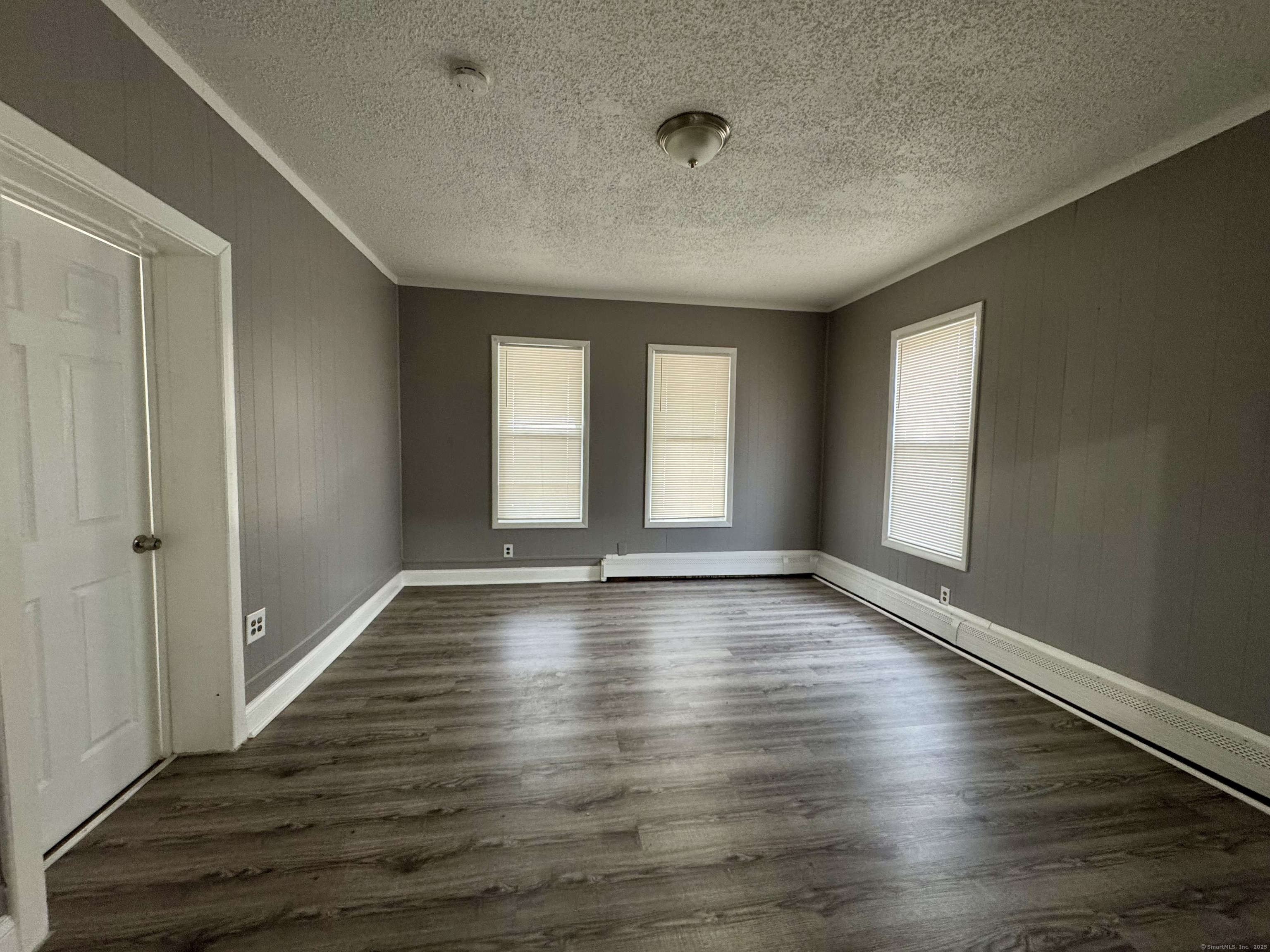 1102 East Main Street, Unit 1 Bridgeport, CT 06608 - Photo 9 of 14 an empty room with wooden floor and windows