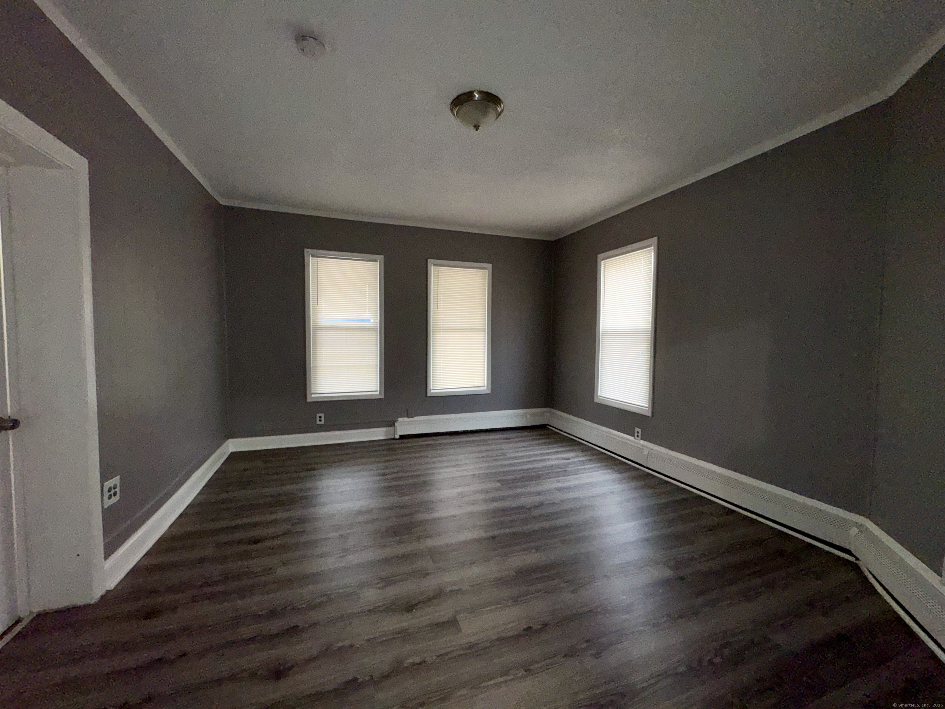 1102 East Main Street, Unit 1 Bridgeport, CT 06608 - Photo 10 of 14 a view of an empty room with wooden floor and window