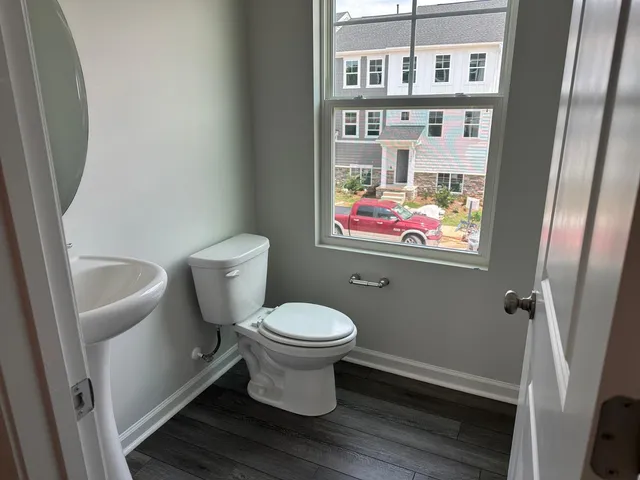 a white toilet sitting next to a bathroom sink and a mirror