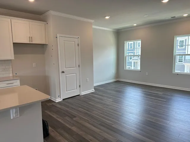 a view of a kitchen with wooden floor and a window