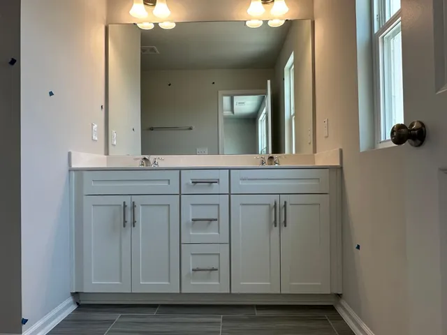 a bathroom with a granite countertop sink and a mirror