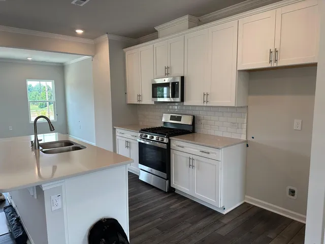 a kitchen with granite countertop a stove and a sink