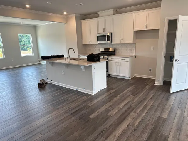 a kitchen with white cabinets and appliances