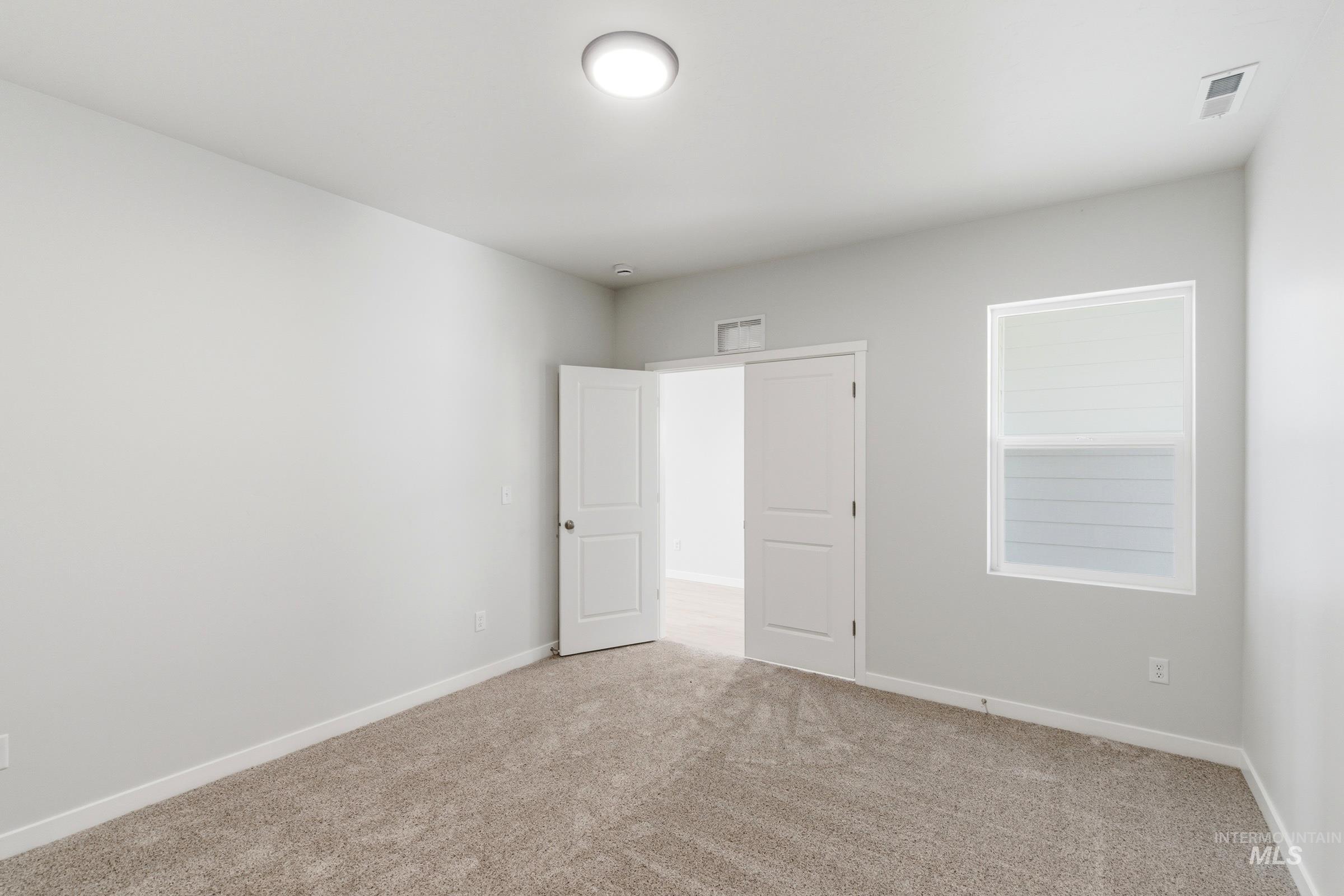 13663 Redway Court Caldwell, ID 83607 - Photo 17 of 32 Plush carpeted room featuring a white trim window, neutral wall paint, white baseboards, and a contemporary ceiling light fixture