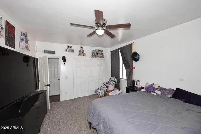 a bedroom with a bed and a flat tv screen on the dresser