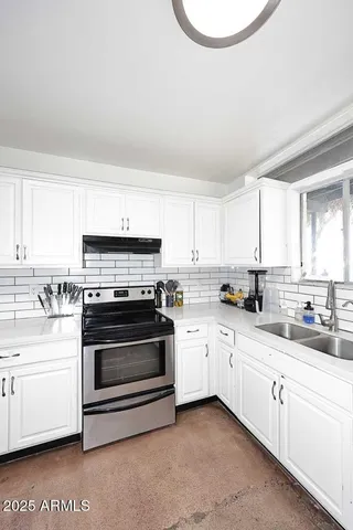 a kitchen with granite countertop white cabinets and white appliances