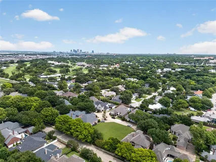 an aerial view of residential houses with outdoor space and trees