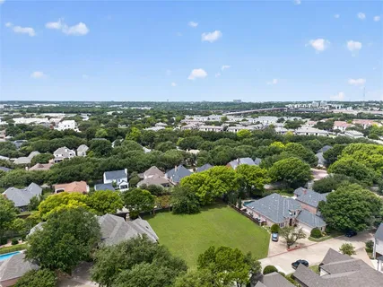 an aerial view of a city with lots of residential buildings ocean and mountain view in back