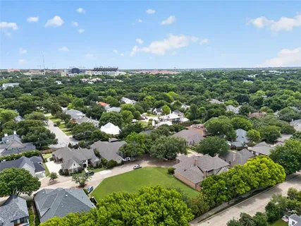 an aerial view of residential houses with outdoor space and trees