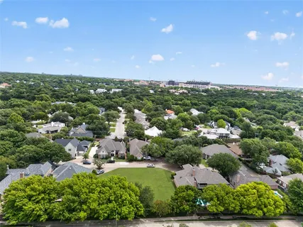 an aerial view of residential houses with outdoor space and trees