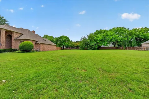 a view of a garden with a house in the background