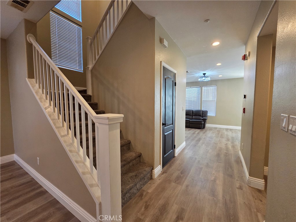 20329 Red Poppy Lane Riverside, CA 92508 - Photo 13 of 31 a view of a hallway with wooden floor and staircase