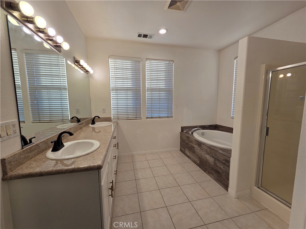 20329 Red Poppy Lane Riverside, CA 92508 - Photo 28 of 31 a bathroom with a granite countertop sink a mirror and a bathtub