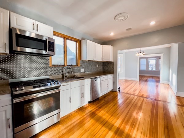 12 Sheldon Street, Unit 2 Boston, MA 02131 - Photo 1 of 1 a kitchen with stainless steel appliances kitchen island granite countertop a stove a sink and a microwave