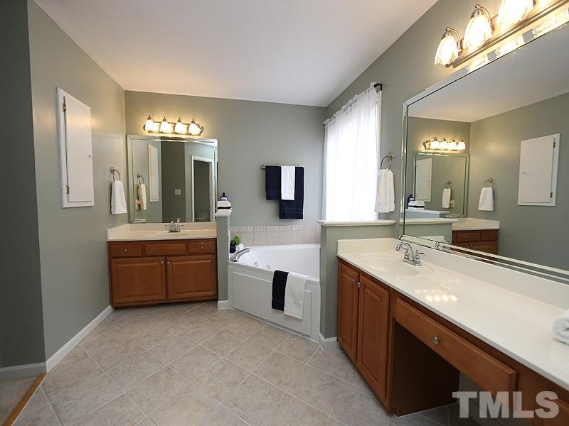 1012 Christy Ridge Court Rougemont, NC 27572 - Photo 15 of 20 a large bathroom with a double vanity sink a large mirror and a bathtub