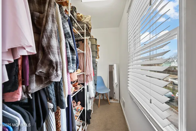 a view of walk in closet with clothes and shoes