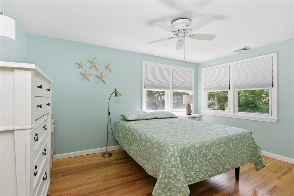 8 Emerald Way Sandwich, MA 02644 - Photo 20 of 36 a spacious bedroom with a bed and a chandelier