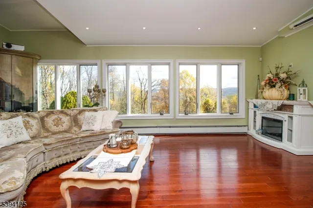 a living room with fireplace furniture and a large window