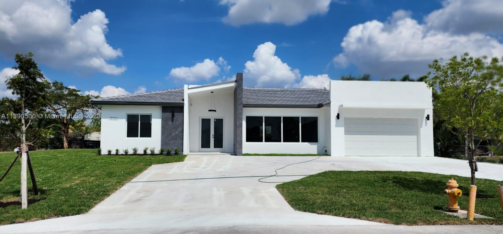 18961 Southwest 359th Street Homestead, FL 33034 - Photo 1 of 54 a front view of a house with a garden and yard