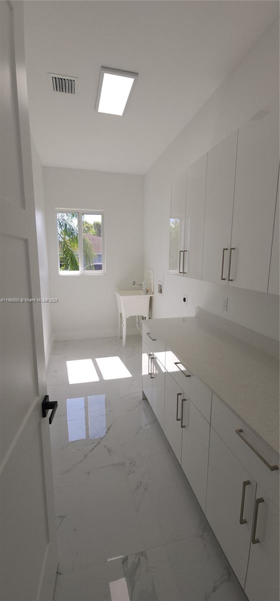18961 Southwest 359th Street Homestead, FL 33034 - Photo 24 of 54 a kitchen with white cabinets and window