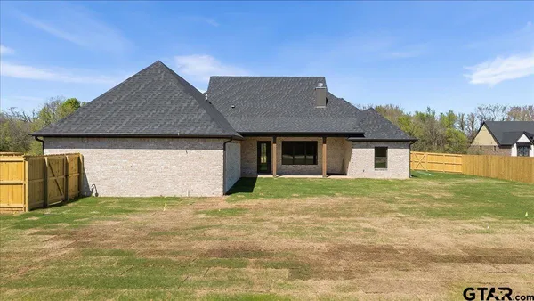 a house with huge green field in front of it