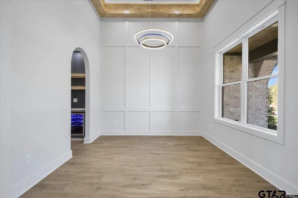 an empty room with wooden floor and exposed radiator