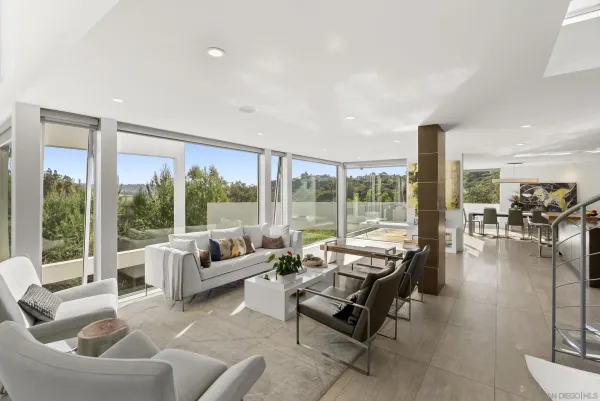 a living room with furniture and floor to ceiling windows