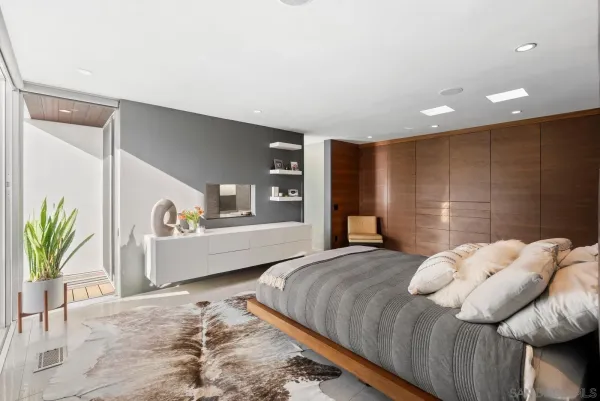 a large bedroom with a bed and large window