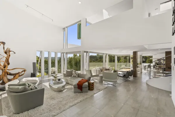 a living room with furniture and floor to ceiling windows