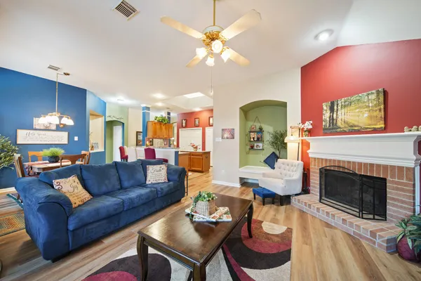 a living room with furniture a chandelier and a fireplace