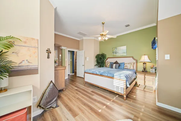 a spacious bedroom with a bed and wooden floor