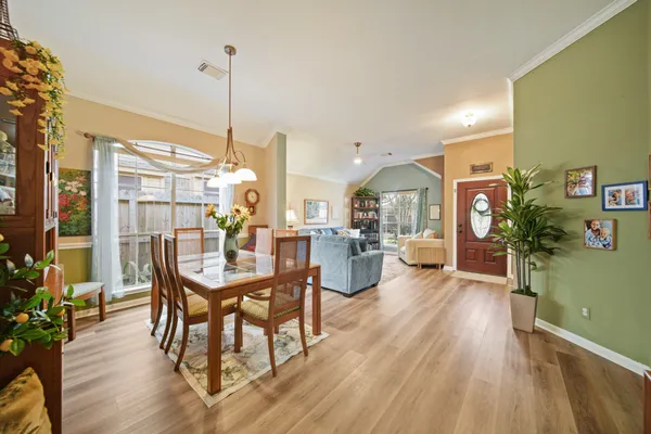 a view of a dining room and livingroom with furniture wooden floor a chandelier