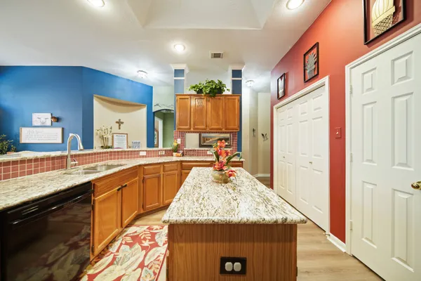 a large kitchen with granite countertop a sink and a wooden floor