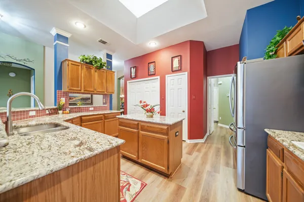 a kitchen with stainless steel appliances granite countertop a sink stove and refrigerator